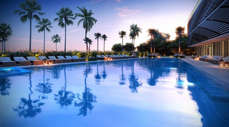 Resort-style pool deck at Sabbia Beach condos with palm trees and sunset ambiance in Pompano Beach, Florida