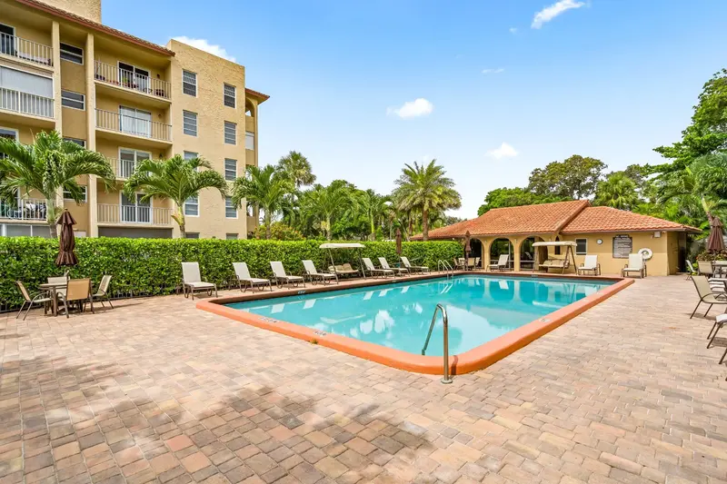 Community swimming pool and tropical landscaping at Tierra Del Mar Condos in Boca Raton, Florida